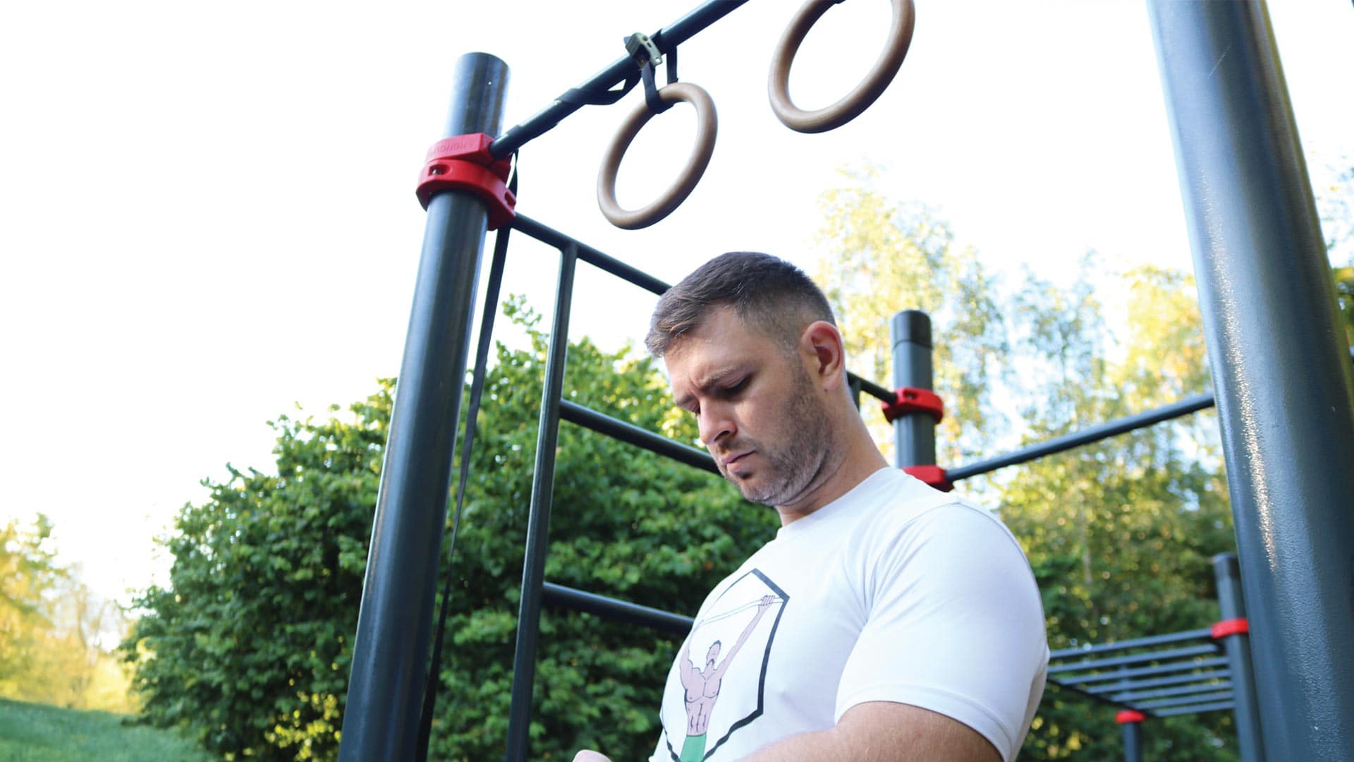 Ivan performing a bodyweight workout under gymnastics rings in an outdoor calisthenics park in Dublin, Ireland