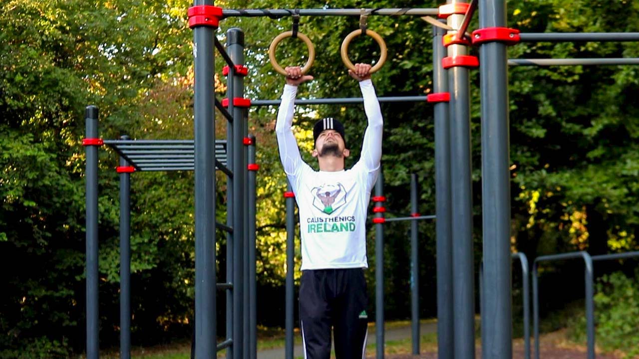 Calisthenics Ireland coach performing controlled bodyweight strength training at an outdoor park